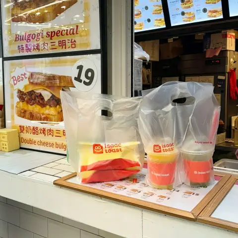 Takeout bags and drinks ready for pickup at the counter