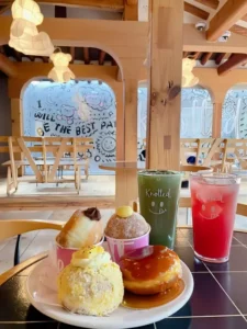 Cafe Knotted Anguk's signature doughnuts and drinks on a wooden table inside their cozy café