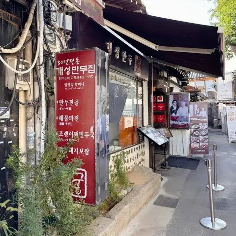 Traditional dumpling restaurant storefront with red signboard in Insadong