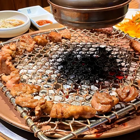Marinated pork circles the charcoal grill evenly