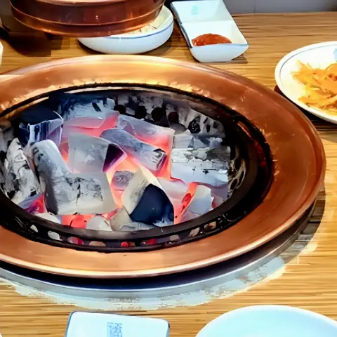 Glowing charcoal setup inside Korean BBQ restaurant