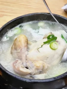 Traditional Baeknyeon Torjong Samgyetang served in a hot stone pot with chicken and broth
