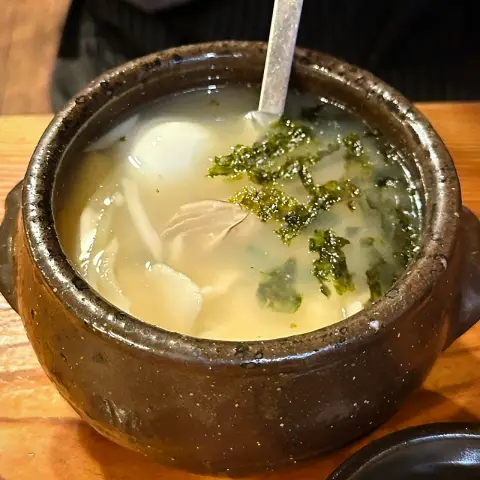 Earthen pot of hot sujebi with seaweed garnish