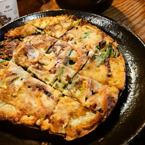 Golden seafood pancake served on a hot plate