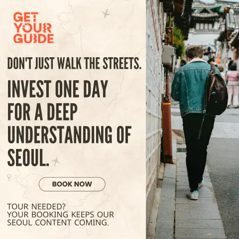 A person in a denim jacket and black pants walks away from the viewer down a narrow, traditional street in Seoul, flanked by a white brick wall and a distant view of other pedestrians. The GetYourGuide logo is in the top left corner, with the main text: "DON'T JUST WALK THE STREETS. INVEST ONE DAY FOR A DEEP UNDERSTANDING OF SEOUL." A "BOOK NOW" button is below, and a smaller text at the bottom reads: "TOUR NEEDED? YOUR BOOKING KEEPS OUR SEOUL CONTENT COMING."