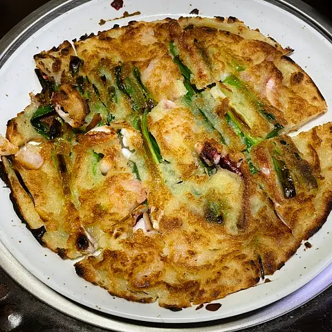 Crispy seafood pancake with shrimp and green onions served hot