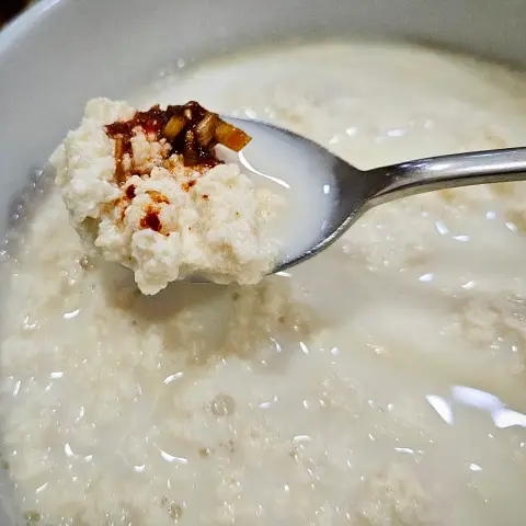 Spoonful of plain Chodang Sundubu with savory seasoning at Jaedong Sundubu.