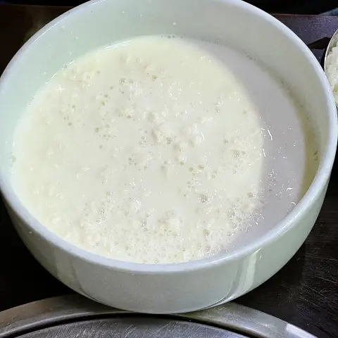 White bowl of Chodang Sundubu, illustrating the fresh, liquid texture.