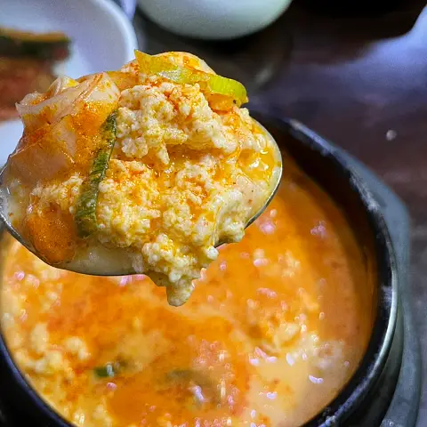 A spoonful of spicy kimchi-flavored tofu from the Sundubu-jjigae at Jaedong Sundubu.