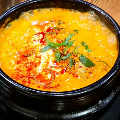 Bubbling Seafood Sundubu-jjigae in a black pot at Jaedong Sundubu.