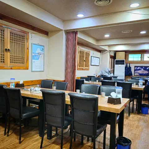 Main dining area with tables and traditional windows inside Jaedong Sundubu.