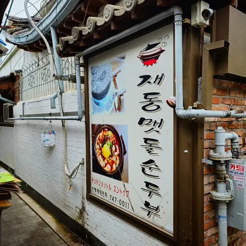 Outdoor menu sign for Jaedong Sundubu showing Dolsot Sundubu.