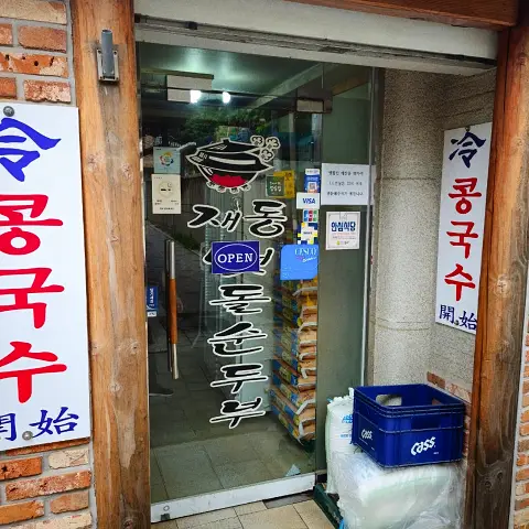 Entrance and glass door of Jaedong Sundubu with 'Open' sign.