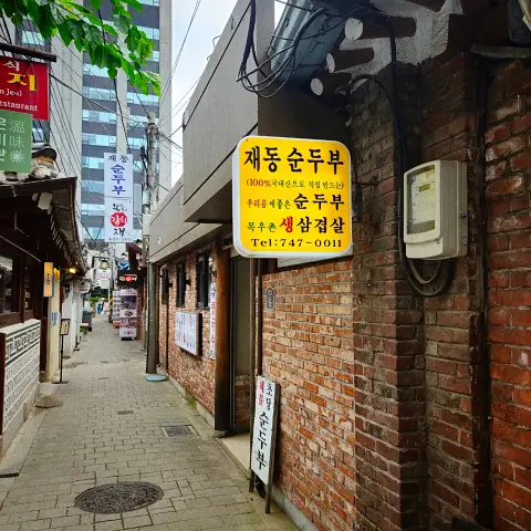 Alleyway entrance sign for Jaedong Sundubu in Bukchon Hanok Village.