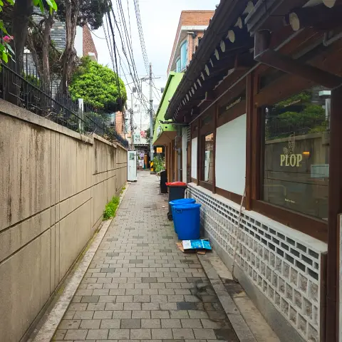 Alley leading up to Jaedong Sundubu, featuring a hanok wall.