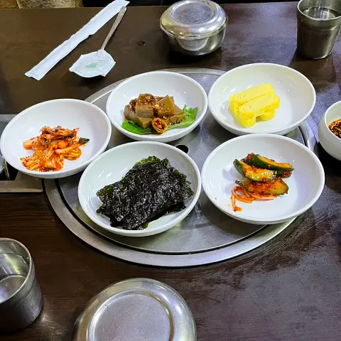 Full Korean meal setting with traditional side dishes on a round tray